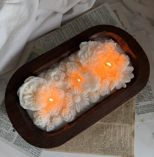 Bring the beauty of spring into your home with our handcrafted Spring Blossom Candle, poured into a rustic wooden dough bowl and adorned with delicate floral details and a sculpted couple centerpiece. 